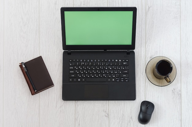 Ordinateur portable, souris d'ordinateur, tasse de café et cahier. Vue de dessus