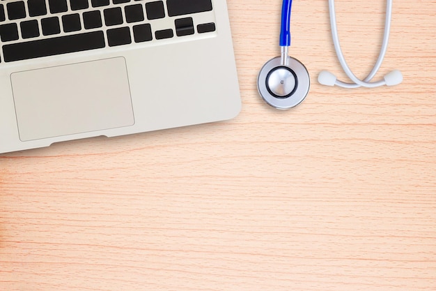 Ordinateur portable avec stéthoscope bleu sur un bureau en bois