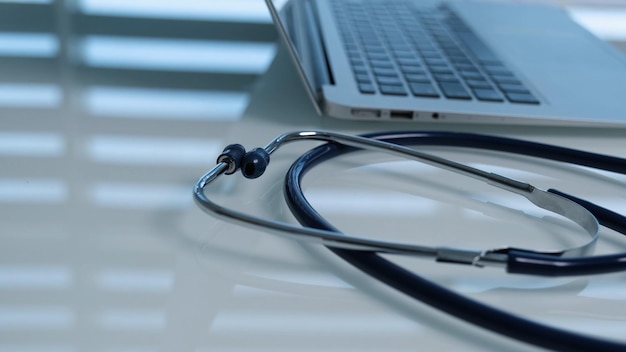 Un ordinateur portable avec un stéthoscope est posé sur un bureau.