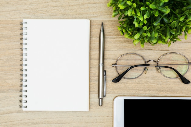 Ordinateur portable avec un stylo sur la table de bureau en bois