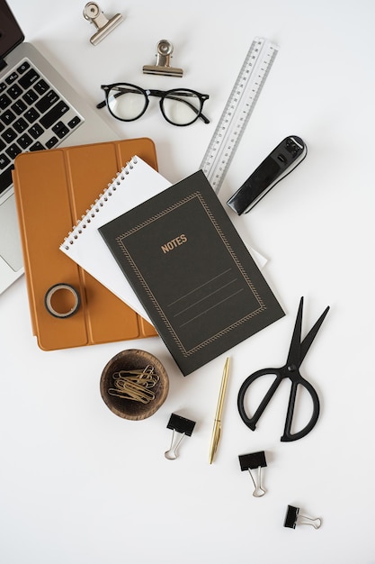 Ordinateur portable tablette pad notes feuille sur fond de tableau blanc Mise à plat vue de dessus esthétique minimal pigiste blogueur bureau à domicile espace de travail