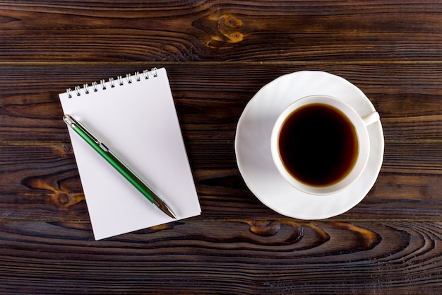 Ordinateur portable avec une tasse de stylo et café sur fond en bois