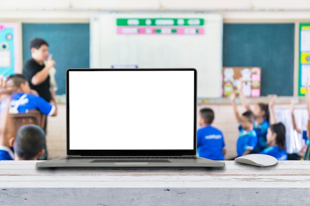 Photo l'ordinateur sur la table floue l'image des enfants dans la salle de classe