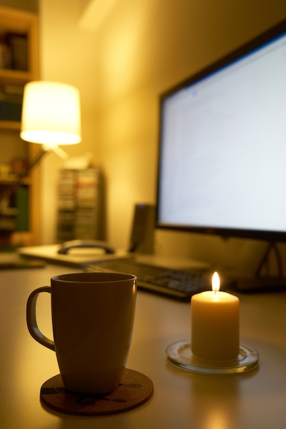 Ordinateur et tasse de café sur un bureau blanc.