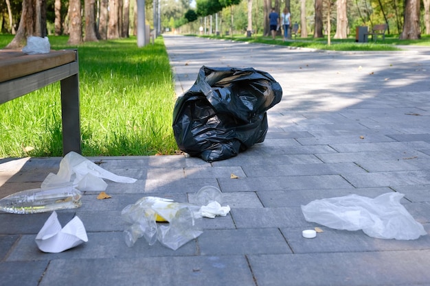 Les ordures des bouteilles en plastique mettent du papier dans le parc de la ville. Problèmes environnementaux