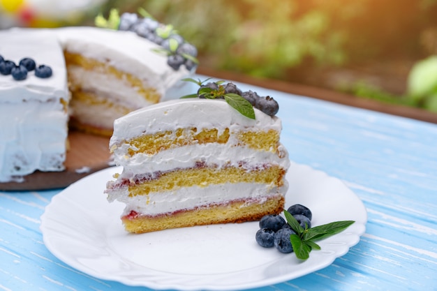Photo oreiller biscuit gâteau au fromage appétissant décoré bleuets crème blanc et menthe se dresse sur la table rustique en bois bleu
