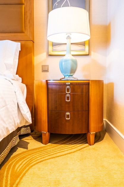 Oreiller blanc confortable sur le lit avec décoration de lampe de table dans la chambre d&#39;hôtel