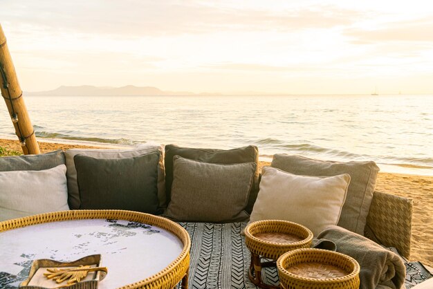 oreiller sur une chaise de patio extérieur avec fond de plage de mer au coucher du soleil