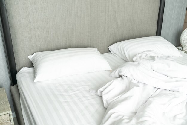 oreiller sur le lit et avec la couverture en désordre rides dans la chambre