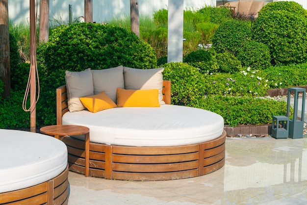 Oreillers sur chaise de patio extérieur avec parasol dans le jardin