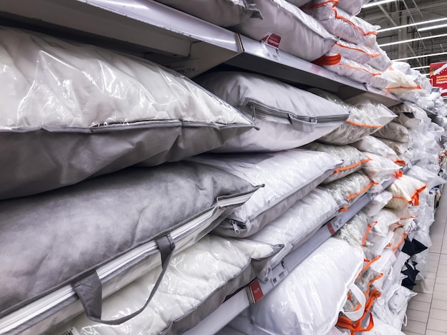 Photo des oreillers dans le magasin blancs pour dormir empilés sur l'étagère d'un magasin de literie sommeil concept