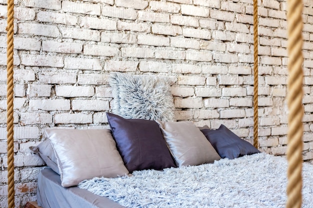 Oreillers sur lit en bois à l'intérieur loft d'une chambre moderne et élégante.