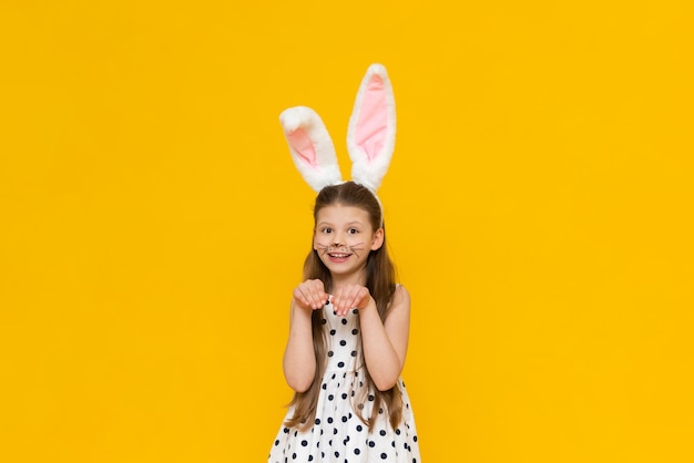 Oreilles de lapin de Pâques sur une petite fille La fille a une moustache de lapin peinte sur elle