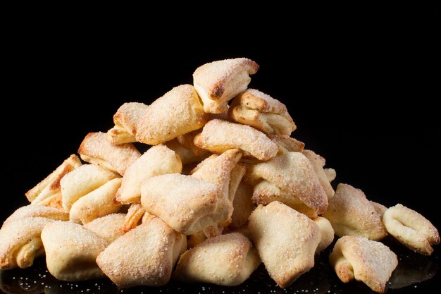 Oreilles de pâte feuilletée de biscuits sur un fond foncé