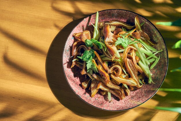 Oreilles de porc marinées et frites dans une poêle. Cuisine chinoise.