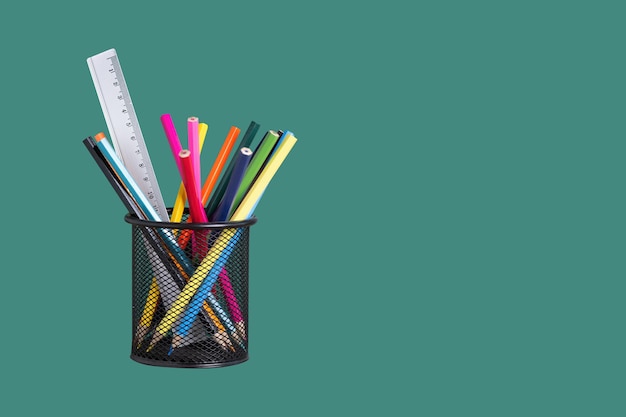 Organisateur de bureau avec des crayons colorés sur fond vert