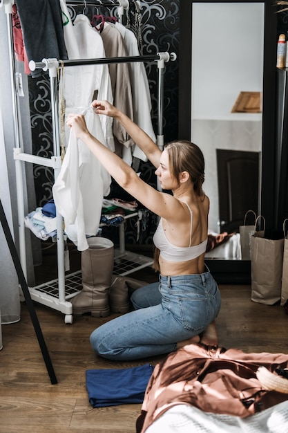 Photo organiser un placard désencombrer une garde-robe jeune femme désencombrer une garde-robe et choisir des vêtements dans