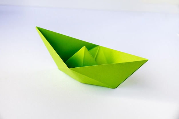 Origami bateau papier vert isolé sur fond blanc