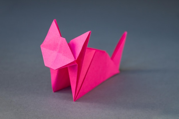 Origami de chat en papier rose isolé sur fond gris