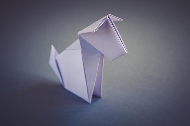 Origami de chien en papier blanc isolé sur fond gris