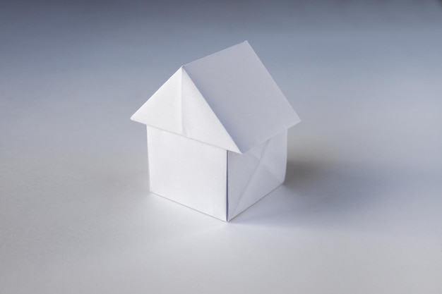 Origami de maison de papier isolé sur fond blanc