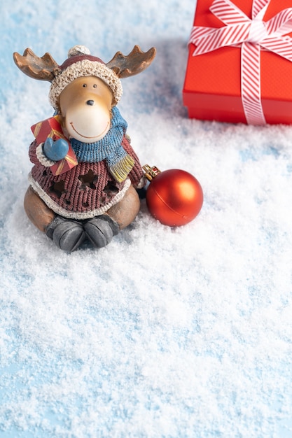 Photo un orignal du nouvel an, des décorations de noël et un coffret cadeau dans la neige. carte de noël. photo de haute qualité
