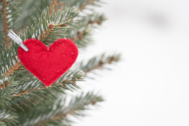 Photo ornement décoratif en forme de coeur saint-valentin dans un arbre de noël a