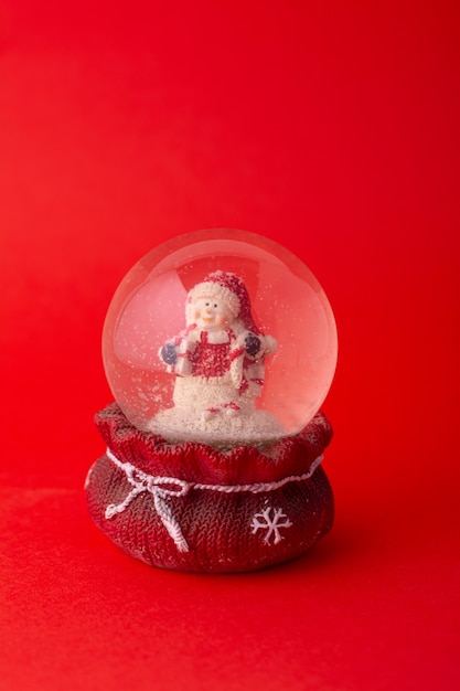 Ornement de Noël avec le père noël en boule de verre sur fond rouge