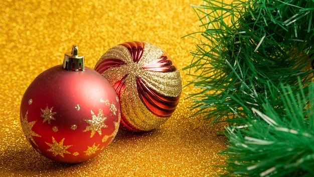 Ornements de Noël en plastique et paillettes et guirlande de Noël sur une surface de paillettes d'or. mise au point sélective.