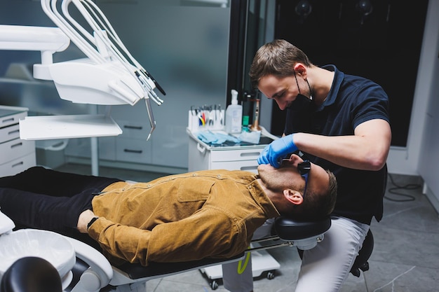 Un orthodontiste traite les dents de son patient dans un bureau moderne et lumineux Traitement orthodontique des dents