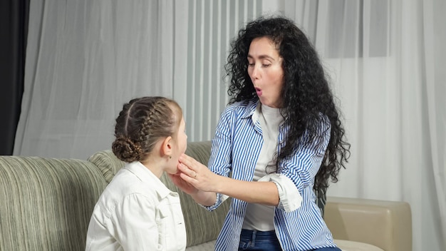 Un orthophoniste aide une fille à produire un son correct à la maison