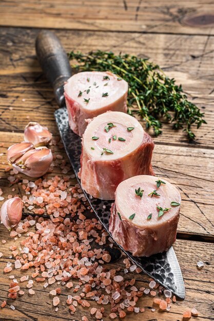 Os à moelle de boeuf, viande crue aux herbes. Fond en bois. Vue de dessus.