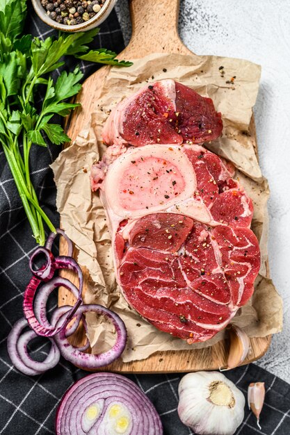 Osso buco cru aux herbes sur une planche à découper