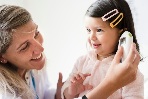 Otorhinolaryngologiste vérifiant une petite fille douce