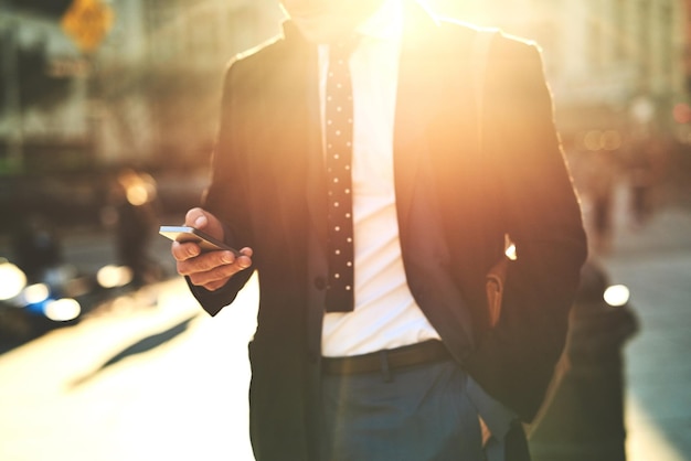 Où le monde l'emmènera-t-il aujourd'hui Photo d'un homme méconnaissable envoyant des SMS sur son téléphone portable tout en marchant dans les rues animées de la ville le matin