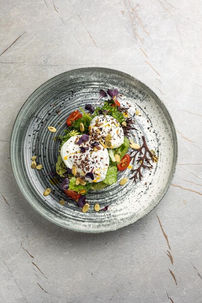 Oue poché avec des tomates à la cerise à l'avocat et de la salade de ragoule