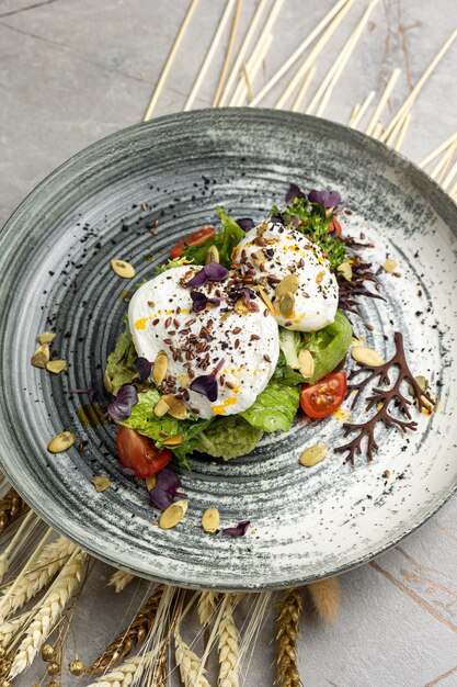 Oue poché avec des tomates à la cerise à l'avocat et de la salade de ragoule