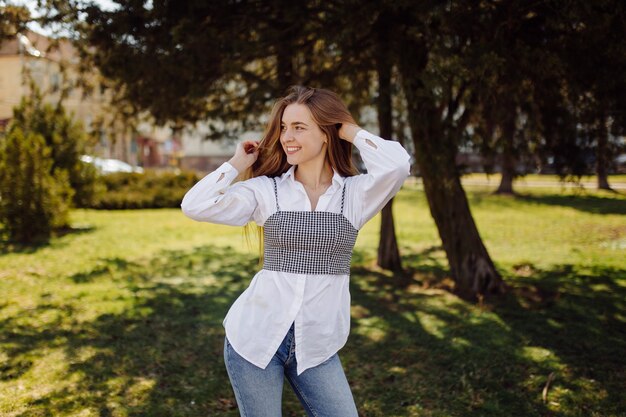 Ã Â oung jolie fille se promène dans la ville en souriant et posant