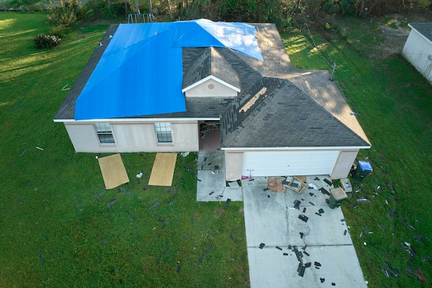 L'ouragan Ian a endommagé le toit de la maison recouvert d'une bâche de protection en plastique contre les fuites d'eau de pluie jusqu'au remplacement des bardeaux d'asphalte Suite à une catastrophe naturelle