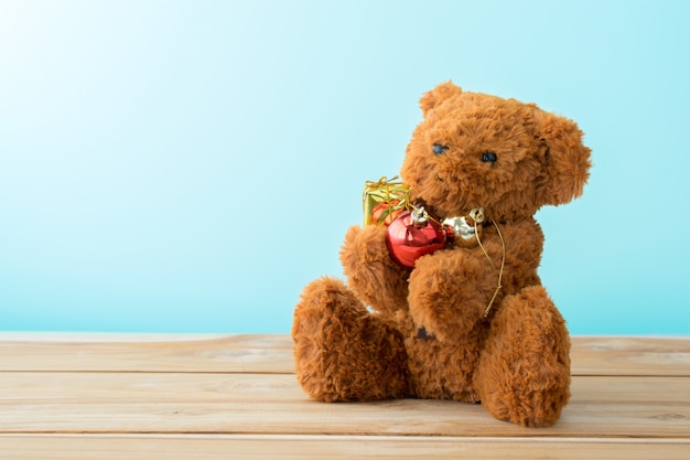 Ours en peluche câlin cadeau bulle de Noël sur table en bois.