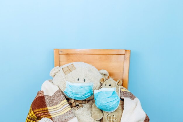 Photo ours en peluche et hippopotame dans un masque médical sur un mur bleu. concept de pandémie de coronavirus covid-19 2019-20.