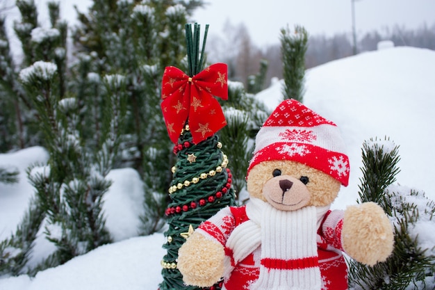 Photo ours en peluche mignon sur fond de neige blanche