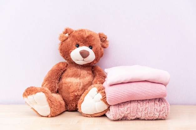 L'ours en peluche se trouve près de la pile de vêtements pour femmes d'hiver ou d'automne.