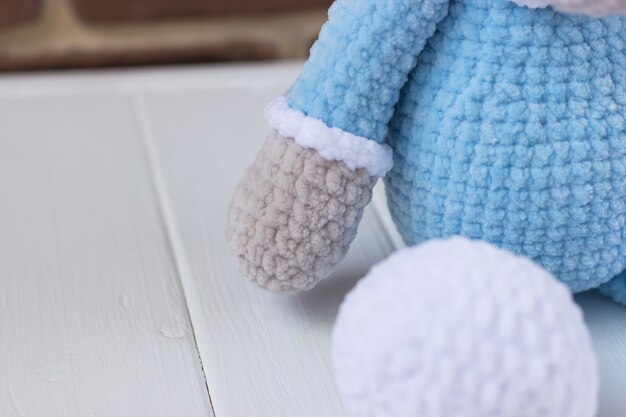 Ours en peluche tricoté en pyjama bleu sur fond blanc