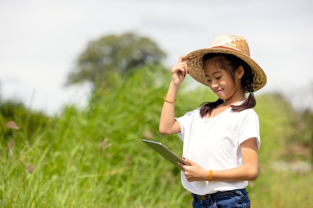 Outdoor Portrait of a Little Girl Farmer sur les champs de riz