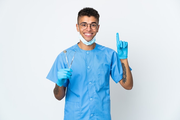 Outil de tenue de dentiste posant isolé contre le mur blanc