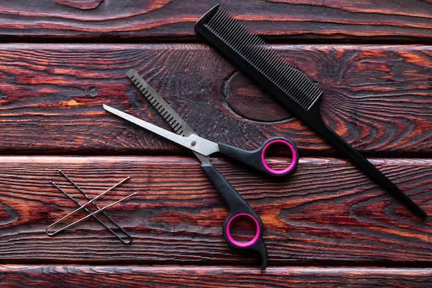 Outils de coiffeur ciseaux et peigne sur un fond en bois