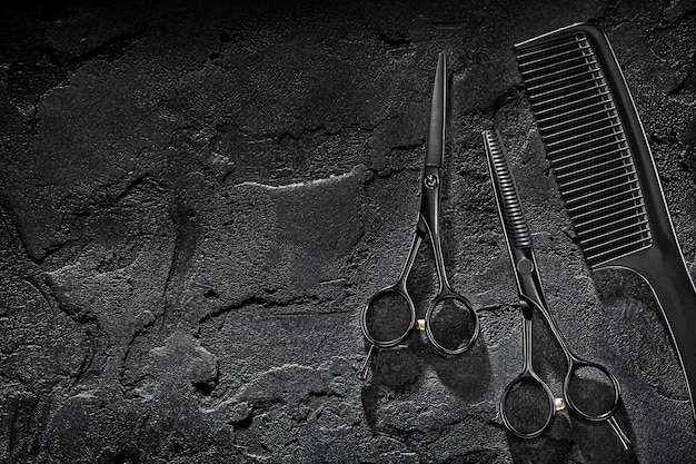 Outils de coiffeur noir salon de coiffure coiffeur professionnel ciseaux de coupe de cheveux et cisailles amincissantes concept de coiffeur fond noir