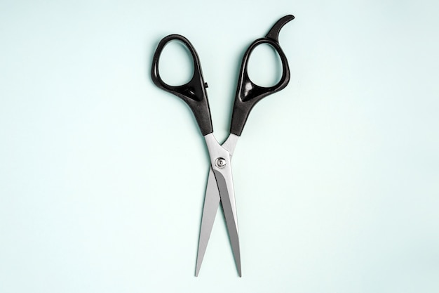 Outils de coiffure ciseaux se trouvent sur un fond bleu