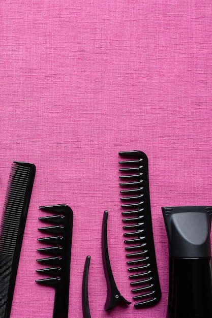 Outils de coiffure sur fond rose et espace pour le texte